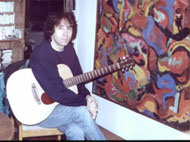 At home in Cortlandt Manor with Martin guitar and painting The Third World, circa late 1990's, early 2000's - click to enlarge